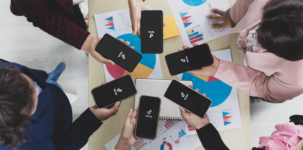 People using smartphones with TikTok logo